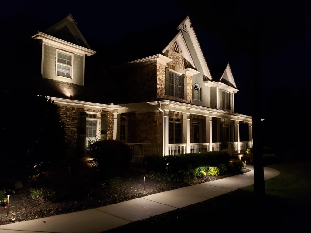 Side shot of a home illuminating thanks to outdoor lighting.