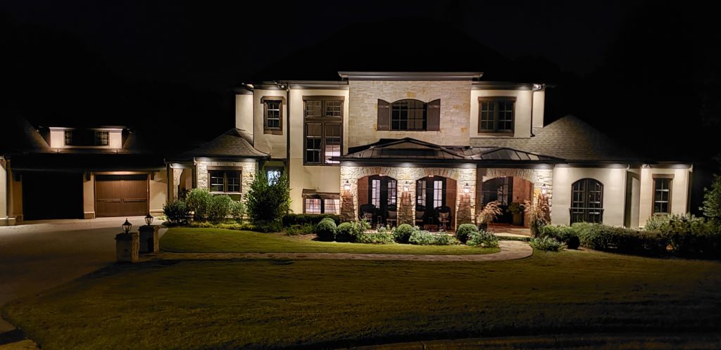 Accent outdoor lighting showing off the front of a home.