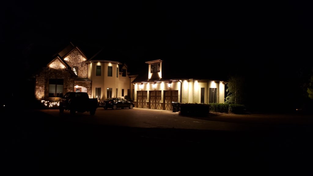 Professional outdoor lighting complimenting a home in the night time.