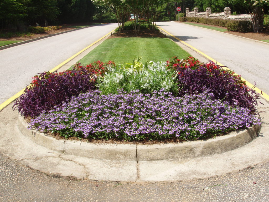 Road island featuring a flowerbed with the help of our commercial landscape design team.